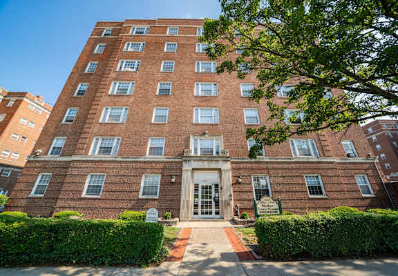 A red brick building with a green lawn in front.