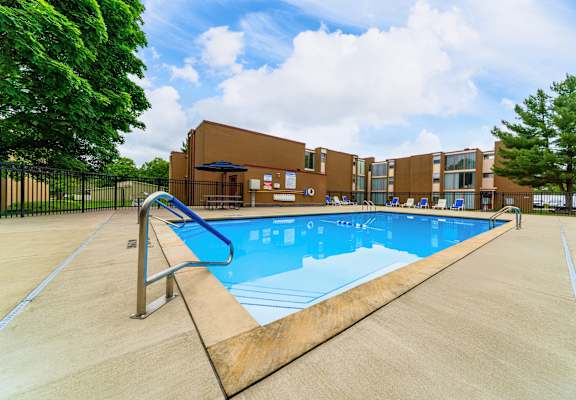 A large outdoor swimming pool with a diving board.