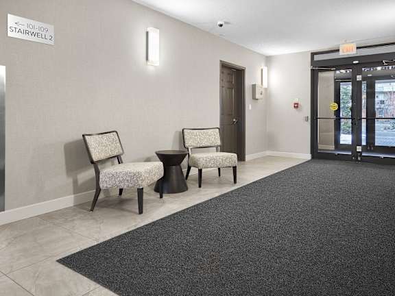 a lobby with two chairs and a door