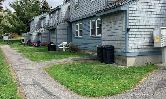 a blue house with a sidewalk in front of it