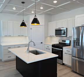 A reception area with a white marble counter and a sign that reads at Alante Homes at Spring Run, Idaho
