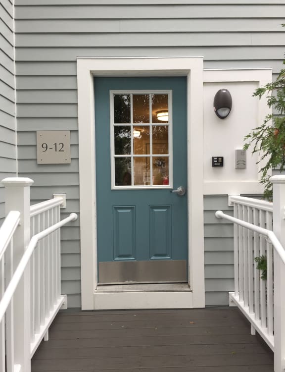 a tiny house with a blue door and a staircase