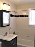 Bath tub area with sink and vanity at Rivercrest Apartments, New Jersey, 08854