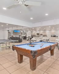 a recreation room with a pool table and ping pong
