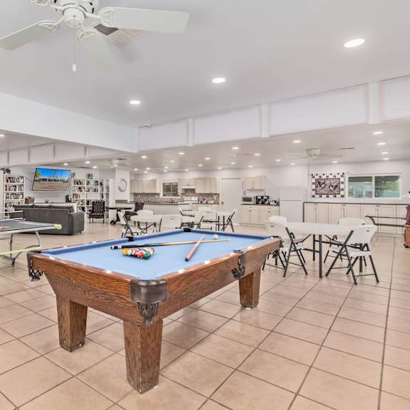 a recreation room with a pool table and ping pong