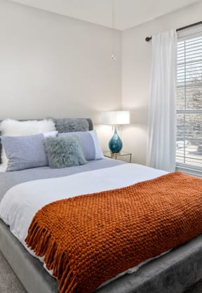 a bedroom with a bed and a large window at The Park at Monterey Oaks, Austin, TX