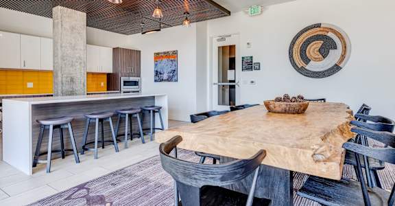 a dining area with a wooden table and chairs and a kitchen with a bar