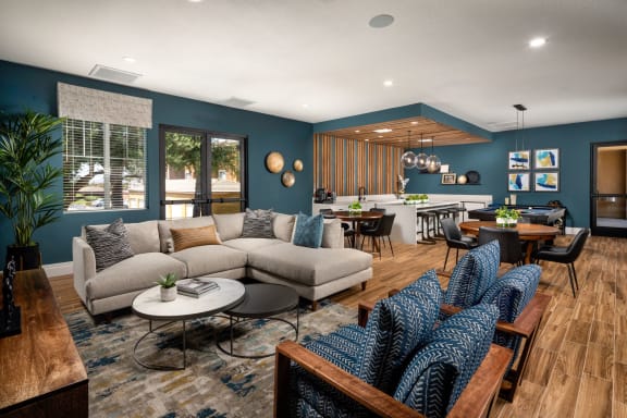 a living room with couches and chairs and a kitchen with a table