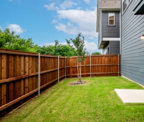 a backyard with a wooden fence and a house