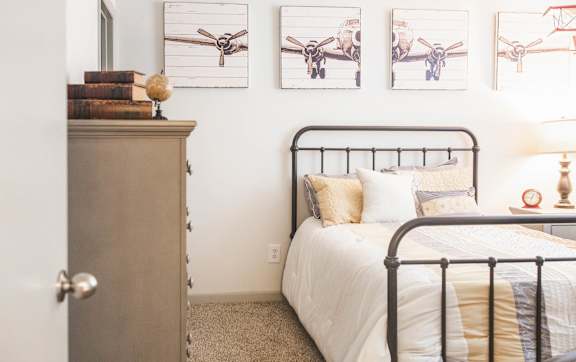 a bedroom with a bed and pictures of airplanes on the wall
