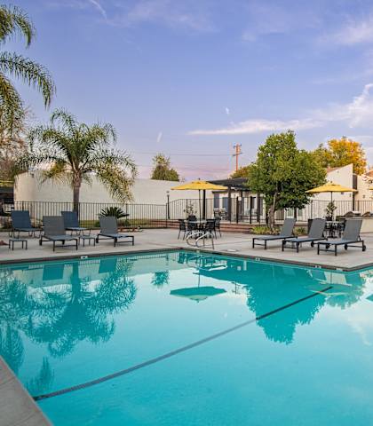 A large swimming pool with a reflection of the surrounding trees.