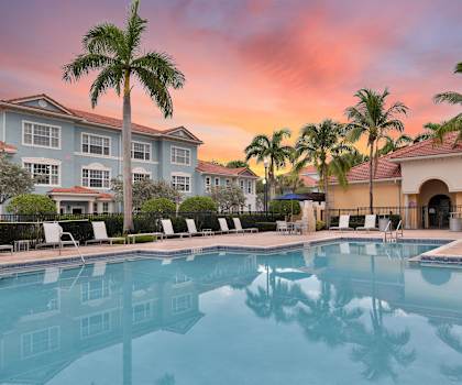 a large swimming pool with a colorful sunset in the background at Floresta, Florida