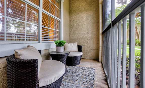 a balcony with wicker chairs and a rug at Estates at Heathbrook, Ocala, Florida