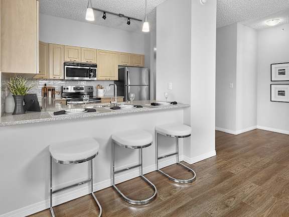 a kitchen with a bar and stools in a house