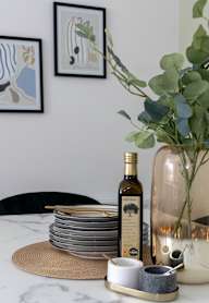 a dining room with a wooden table and blue chairs and a blue wall with artwork
