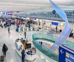 A busy airport check-in area with people standing in line.