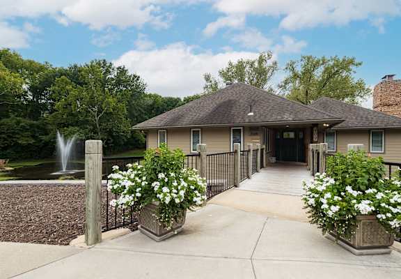 a building with a fountain and flowers in front of it