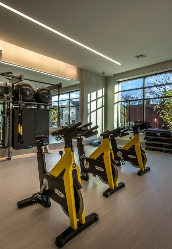 a gym with exercise equipment and large windows