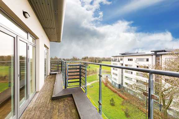 a balcony with a view of a yard and some buildings