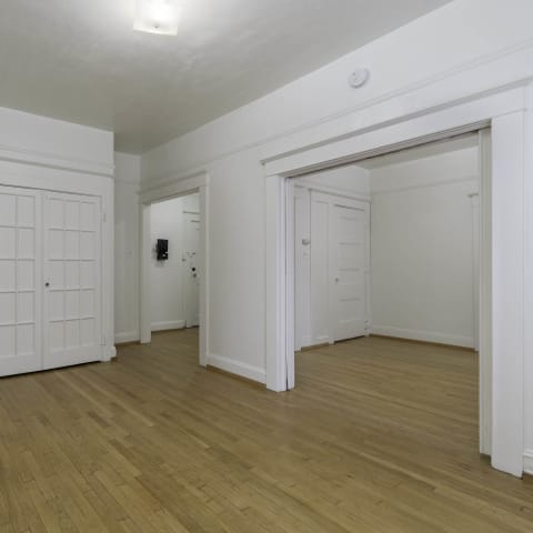the living room and dining room of an empty home with white walls and wood floors at Clay & Tiffany, Portland, OR