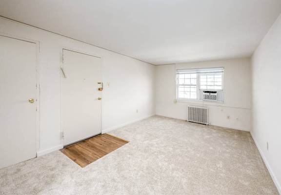 A room with a window and a radiator on the wall.
