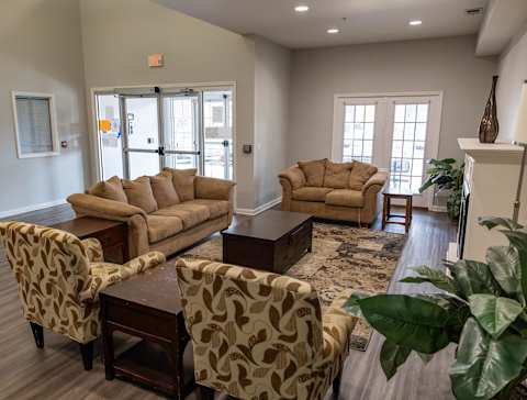 A living room with a couch, chairs, and a coffee table.