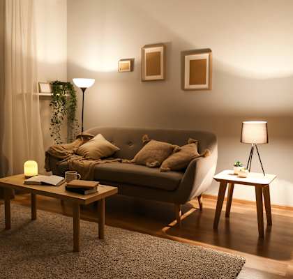 A cozy living room with a couch, a table, and a lamp.