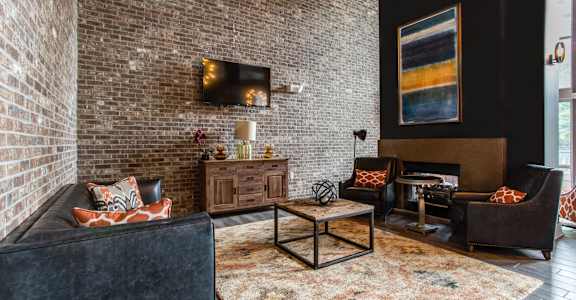 a living room with a brick wall and a couch and a table