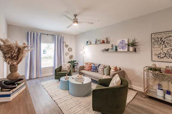 A living room with a green sofa and a white rug.