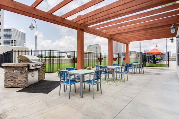 a patio with tables and chairs and a grill