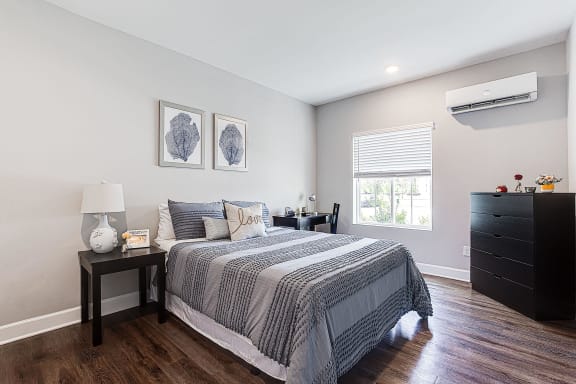 a bedroom with a bed and a dresser and a window