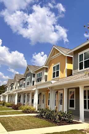 A row of houses with a tree in front of the first one. at Allier Foley in Foley, AL