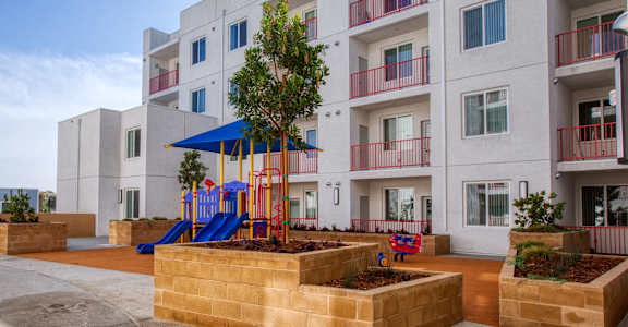 an apartment building with a playground in front of it