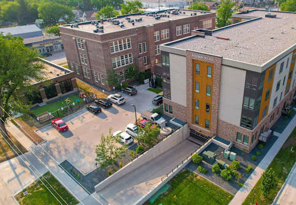 A parking lot in front of a building with a yellow door.