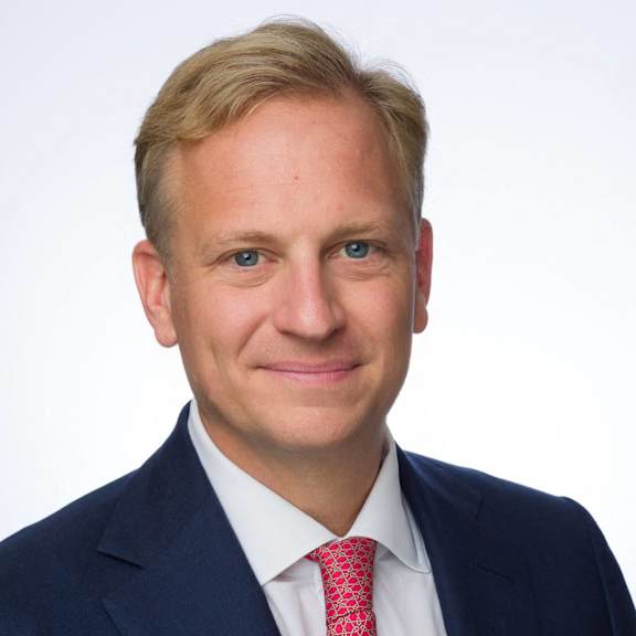 a man wearing a suit and tie and smiling