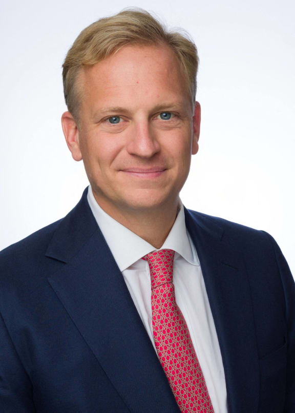 a man wearing a suit and tie and smiling