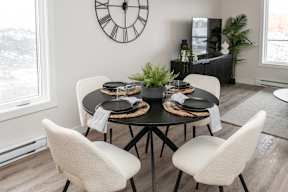 A dining room with a table set for four.