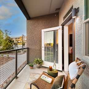 a balcony with a couch and a chair and a fence