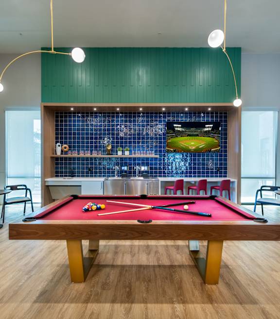 a pool table in a room with a bar and tables
