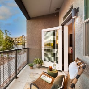 a balcony with a couch and a chair and a fence