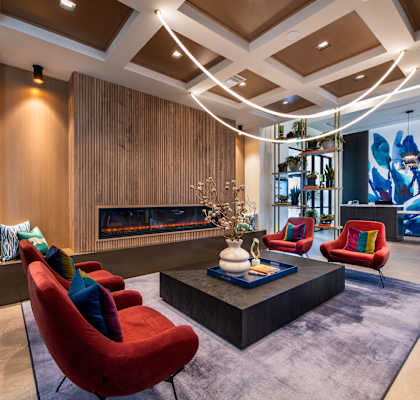 a living room with red chairs and a fireplace