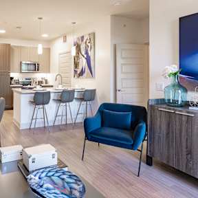 A modern living room with a blue chair and a dining table.