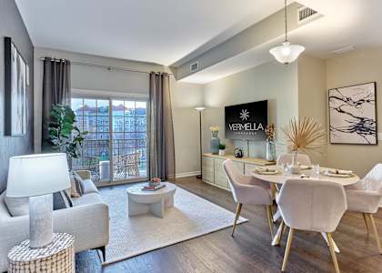A living room with a white sofa, a white coffee table, and a white dining table with white chairs. at Vermella Lyndhurst apartments, Lyndhurst, NJ, 07071