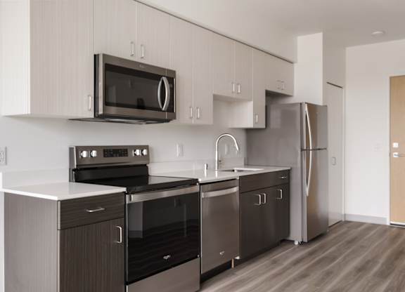 A modern kitchen with stainless steel appliances and wooden floors at Nook at Northaven Apartments, Washington, 98125