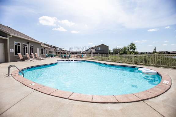 A round above ground pool with a concrete floor and wall.