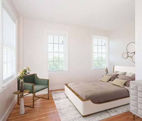 a bedroom with a bed and a dresser and three windows