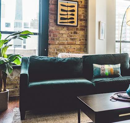 A living room with a green couch and a wooden coffee table.