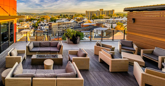A patio with a couch, chairs and a table with a view of the city.at Center Square Lofts East, Allentown, PA 18101