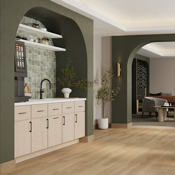 A modern kitchen with a dining area in the background.