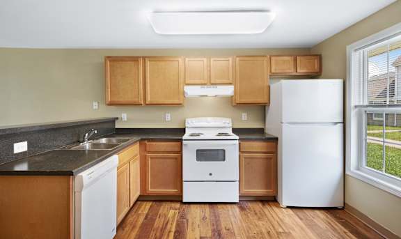 a kitchen with wooden cabinets and white appliances